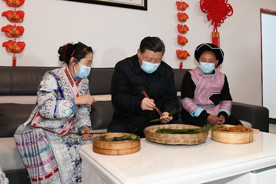 2021年2月3日下午，習近平在貴州畢節(jié)市黔西縣新仁苗族鄉(xiāng)化屋村苗族村民趙玉學家，同一家人邊聊家常邊制作當?shù)貍鹘y(tǒng)節(jié)日食品黃粑。新華社記者 李學仁 攝