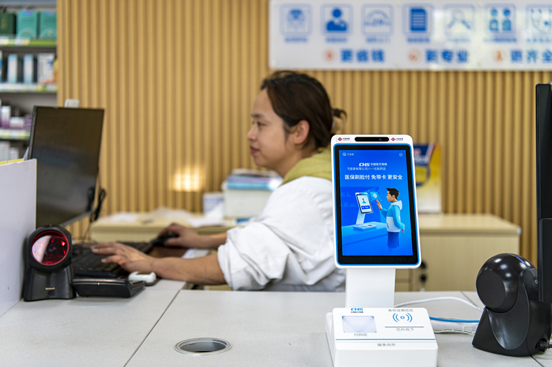 2024年4月10日，浙江金華市區(qū)一家民眾大藥房柜臺(tái)上設(shè)置著醫(yī)保“刷臉支付”機(jī)器，群眾看病更加便利。